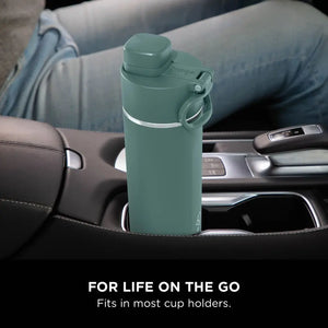 Ninja Thirsti 700ml insulated travel bottle in evergreen green colour positioned in a car cup holder, featuring a secure lid with carry handle and stainless steel band, displayed in a vehicle interior setting with the tagline "For life on the go - Fits in most cup holders"