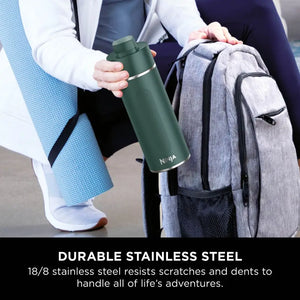 Woman holding Ninja Thirsti 700ml insulated travel bottle in evergreen with grey backpack, showcasing durable 18/8 stainless steel construction