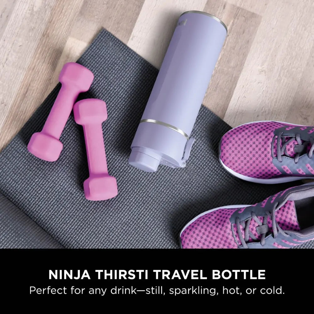 Ninja Thirsti 700ml insulated travel bottle in lavender purple displayed on gray yoga mat with pink dumbbells and pink athletic shoes