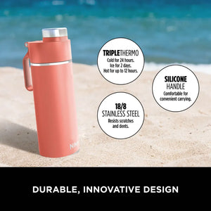 Ninja Thirsti 700ml coral insulated travel bottle on beach sand with ocean background, featuring triple thermo technology, 18/8 stainless steel construction, and silicone handle for carrying