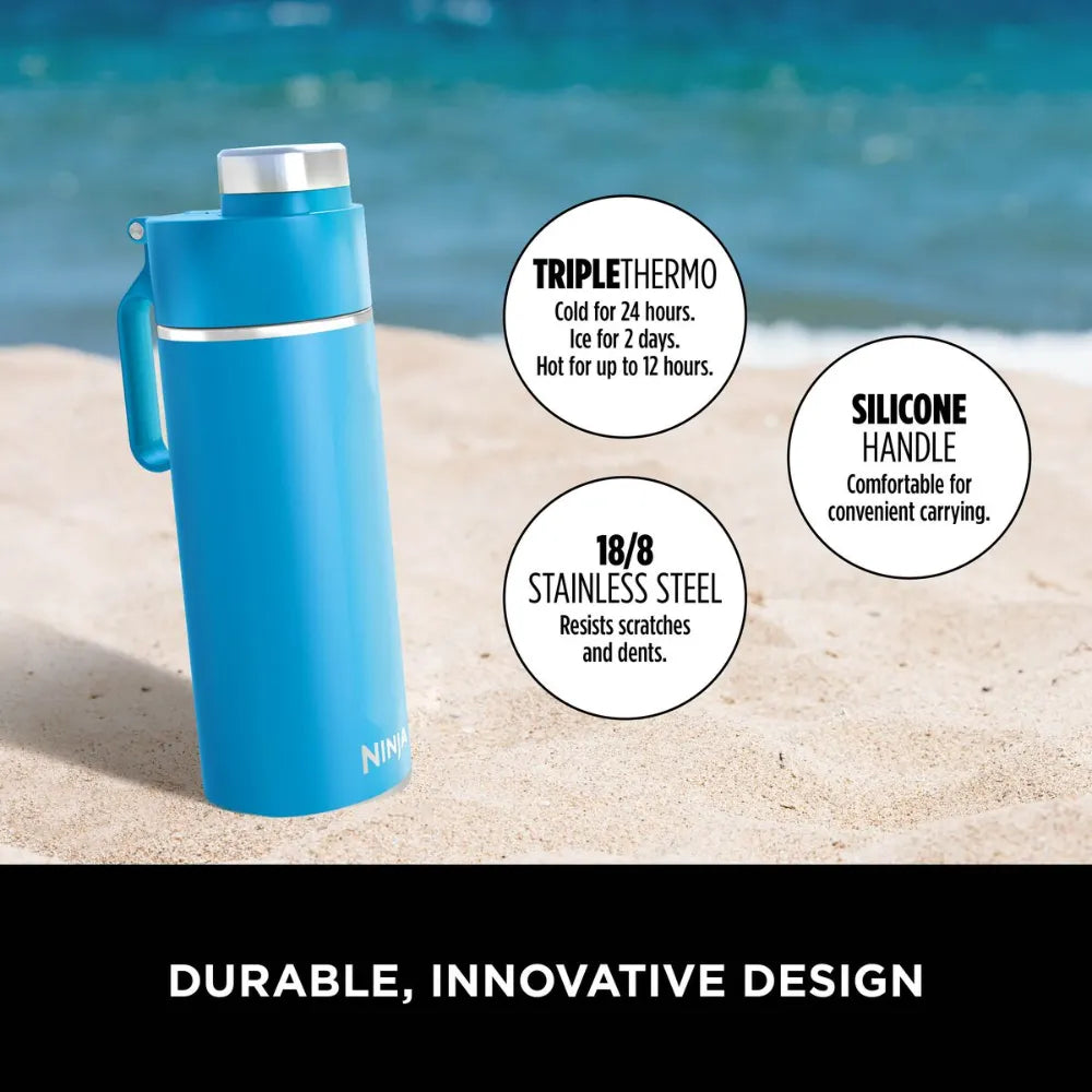 Ninja Thirsti 700ml insulated travel bottle in tropical blue displayed on beach sand with ocean background, featuring triple thermo technology keeping drinks cold for 24 hours or hot for 12 hours, silicone handle for comfortable carrying, and durable 18/8 stainless steel construction