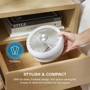 White foldable cordless rechargeable 6 inch desktop fan displayed in wooden shelf storage with styling books, showing compact design and portability features