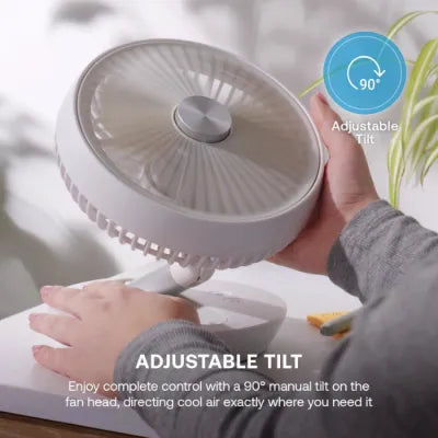 Dimplex cordless rechargeable 6 inch white desktop fan with adjustable 90 degree tilt head being held in hand demonstrating tilt feature
