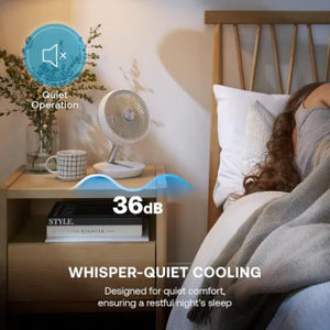 White cordless rechargeable 6-inch desktop fan by Dimplex on wooden bedside table in bedroom setting, showing quiet operation at 36dB with whisper-quiet cooling feature for sleep comfort
