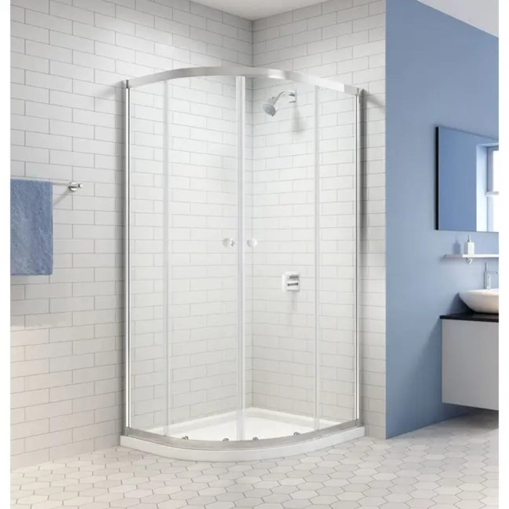 Chrome framed quadrant shower enclosure with clear glass doors installed in a modern bathroom with white subway tile walls and blue accent wall