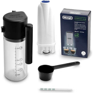DeLonghi Magnifica Start bean to cup coffee machine accessories kit including grey and black milk frother jug with measurement markings, white water filter, black measuring scoop, descaling solution box, and test strips on white background