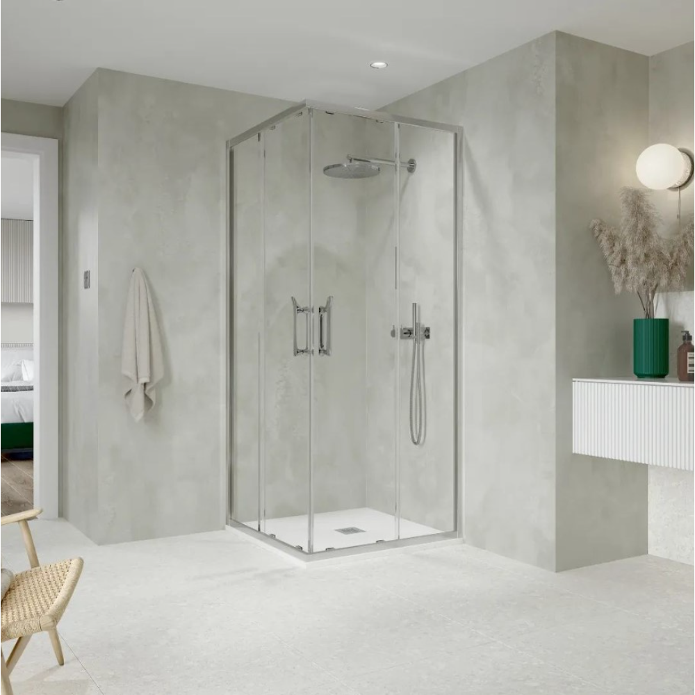 Modern corner entry shower enclosure with chrome frame and clear glass panels in minimalist bathroom with concrete grey walls, white floor, and contemporary fixtures