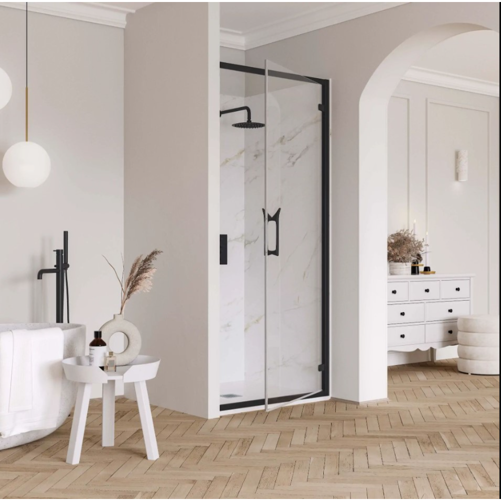 Modern bathroom with Flair ETO hinge shower door featuring matte black frame and clear glass panels, marble-effect tiled shower enclosure, white freestanding bathtub, wooden side table with black tap, herringbone wood flooring, pendant lighting, and white vanity with black handles in contemporary neutral interior design setting
