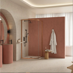 Flair ETO quadrant shower enclosure with brushed bronze frame and clear glass doors in modern bathroom with terracotta accent wall, wooden stool, white towel rail, and natural lighting from vertical blinds