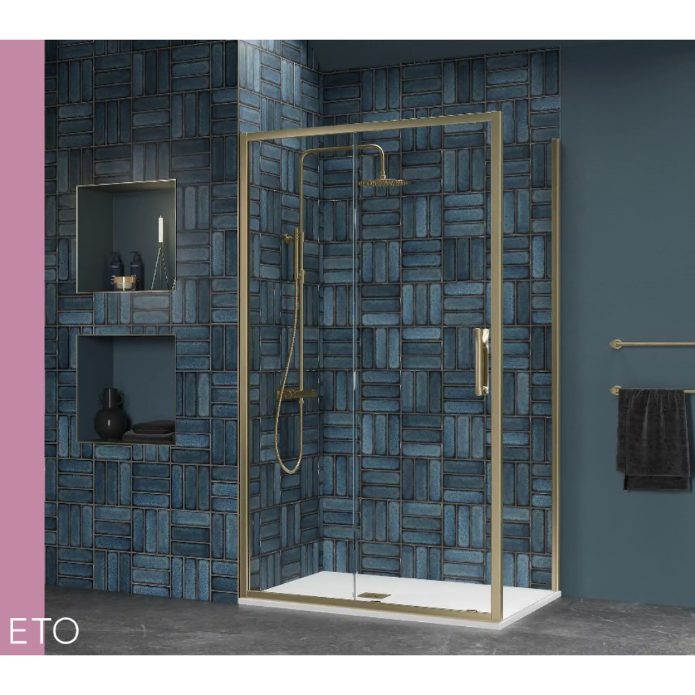 Flair ETO brushed brass sliding shower enclosure with white tray against blue brick tile wall in modern bathroom setting with gold towel rail and pink accent wall