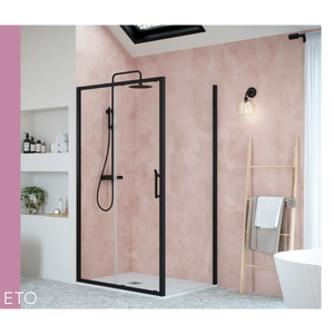 Modern black framed sliding shower enclosure with clear glass panels in pink bathroom with white freestanding bath and wooden towel ladder