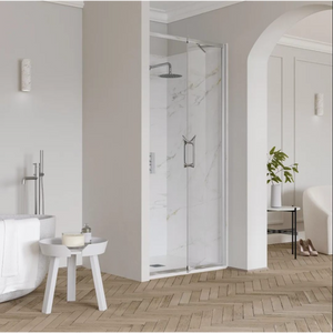 Modern bathroom with Flair ETO Infold shower door in chrome finish, featuring marble tiling, paired with white freestanding bathtub, white side table with plant, herringbone wood-effect flooring and grey walls