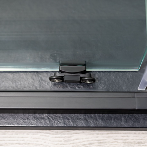 Close-up of Flair ETO Quadrant shower enclosure top bracket in matte black finish showing chrome hinges and clear glass panel against dark frame mounted on bathroom wall