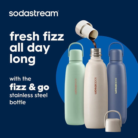 Sodastream fizz and go stainless steel bottles in mint green, cream white, and navy blue with handles, displayed against a blue circular background with product carbonation being dispensed from the white cap of the center bottle