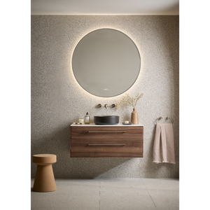 Modern bathroom vanity unit with walnut wood finish, wall-mounted design, featuring a black ceramic basin, illuminated circular mirror with LED backlight, brushed brass wall-mounted tap, complemented by neutral textiles and minimalist decor in contemporary spa-like setting