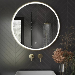 Aqualla Fuse Frame Round LED Bathroom Mirror 700mm in black with brushed brass fixtures mounted on dark herringbone tile wall above white basin with rainfall showerhead visible in reflection