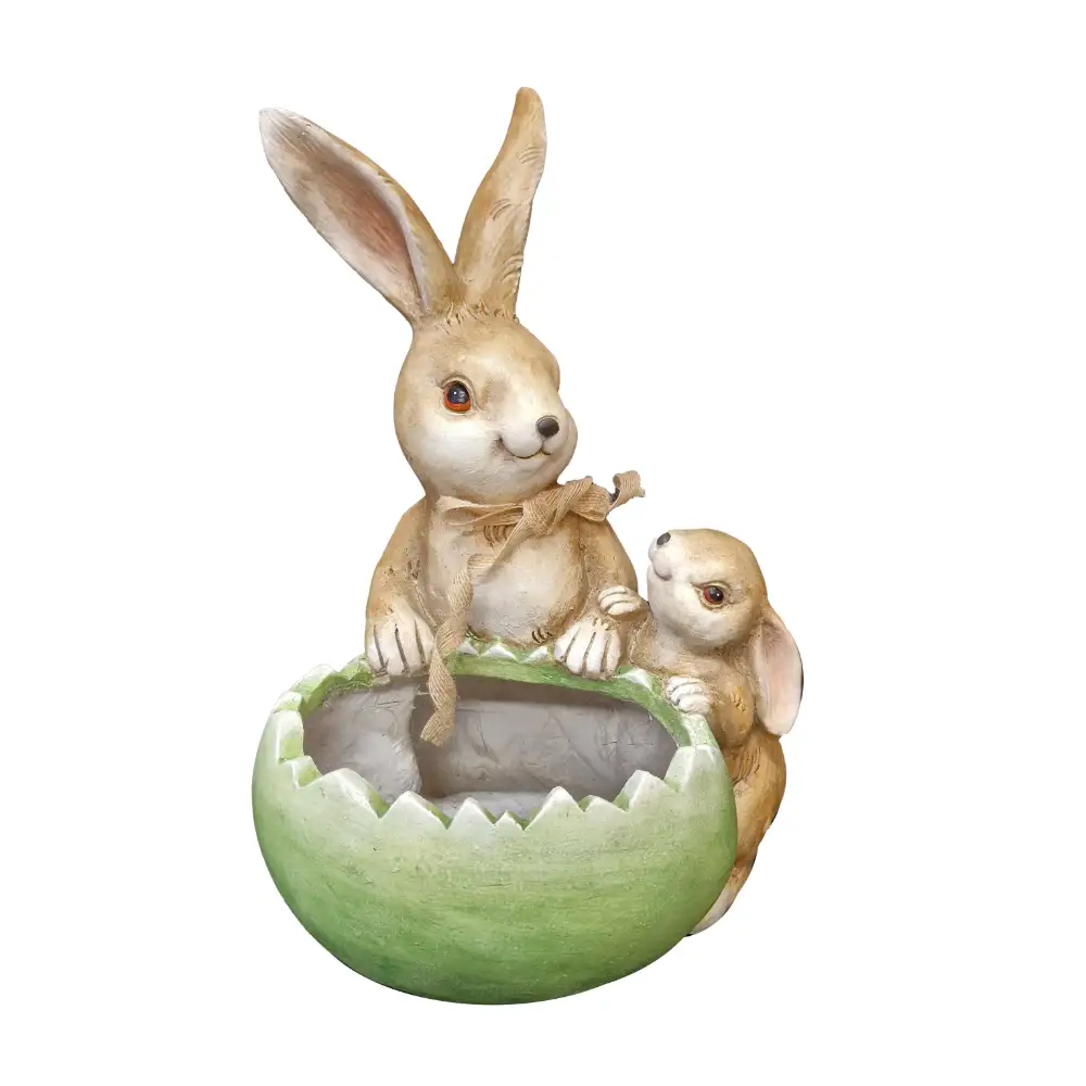 Ceramic garden planter featuring a mother rabbit with long ears wearing a tan bow and a smaller baby rabbit, both seated in a green cracked egg-shaped pot with weathered cream and tan finishes