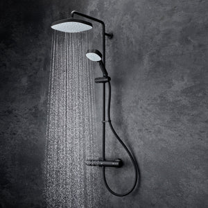 Mira Relate dual bar mixer shower in matt black with overhead rainfall showerhead and handheld spray, mounted on textured grey tile wall, water streams visible