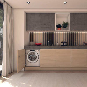 Hoover H-Wash 300 integrated washing machine built into light wood cabinetry in a modern laundry room with dark grey countertop, vertical slat backsplash, upper storage cabinets and potted plants