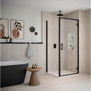 Modern bathroom featuring Flair ILI hinged shower door with matte black frame and chrome hardware, installed in a neutral beige tiled enclosure with rainfall showerhead, alongside a freestanding black bathtub and wooden accent table