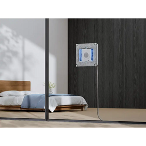 Ecovacs Winbot Mini beige robot window vacuum mounted on dark wood wall next to bedroom with wooden bed and mirror reflection