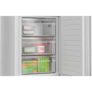 Open Bosch Series 4 white fridge freezer showing three transparent drawers with fresh vegetables, frozen foods, and packaged items inside
