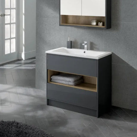 Modern anthracite floor standing bathroom vanity unit with white ceramic sink, integrated open shelving with natural wood accent, matching wall mounted mirror cabinet, chrome tap and accessories in contemporary grey tiled bathroom