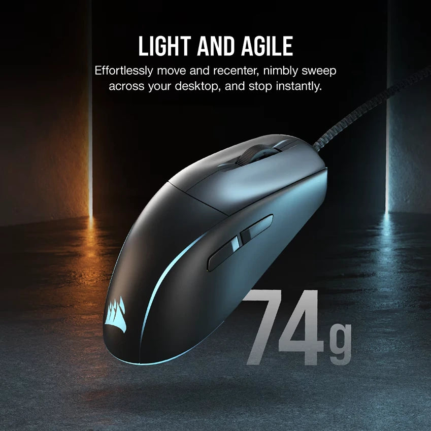 Corsair M75 lightweight gaming mouse in black with RGB lighting, weighing 74g, displayed against a dark background with blue and orange ambient lighting, showing ergonomic design with braided cable