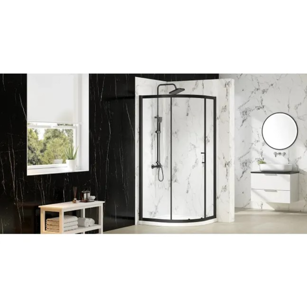 Merlyn MBox quadrant shower enclosure with black frame and clear glass panels in modern bathroom with marble tiles, white vanity unit and round mirror