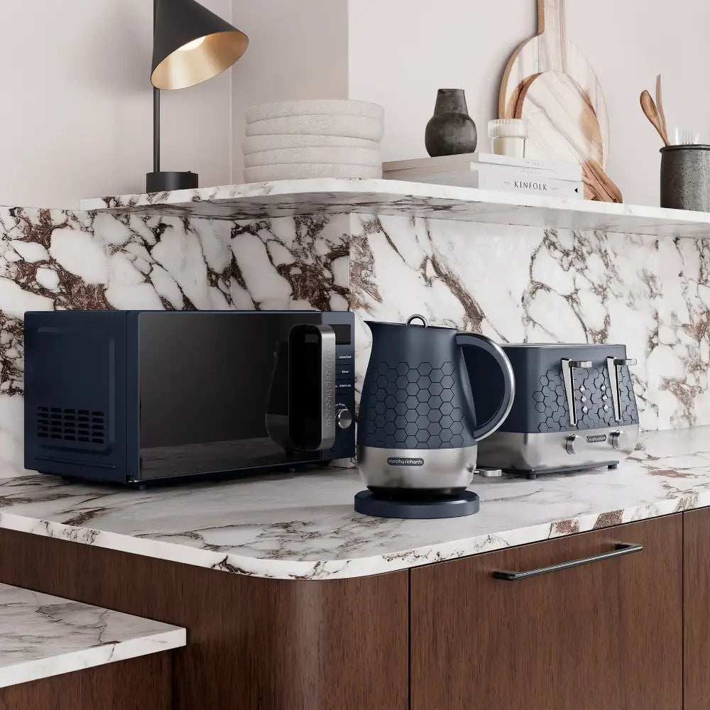 Morphy Richards Cassini Digital Microwave in Outer Space navy blue with 20 litre capacity displayed on marble countertop beside matching navy kettle and toaster in modern kitchen with white and brown cabinetry