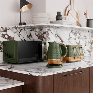 Morphy Richards Cassini olivine green microwave displayed on a marble countertop alongside matching green kettle and toaster, modern kitchen setting with wooden cabinetry and decorative accessories