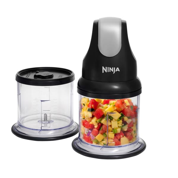 Ninja Professional Stackable Chopper 200W NJ1002UKBK with black motor base and white top, featuring two clear plastic bowls, one empty and one filled with chopped red peppers, yellow corn and green vegetables