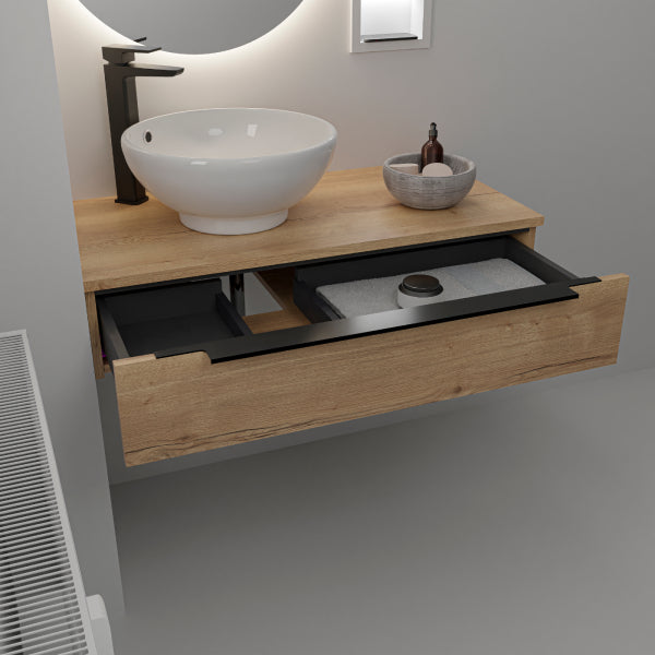 Wall-mounted bathroom vanity unit in Halifax Oak with open drawer showing black interior storage, white round ceramic basin, black tall faucet, illuminated round mirror, and decorative grey basket on natural wood countertop