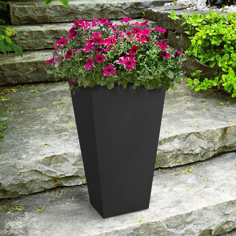 Tierra Verde Sonata slate grey square garden planter 70cm tall with vibrant magenta petunias and green foliage planted on a stone patio against natural stone steps