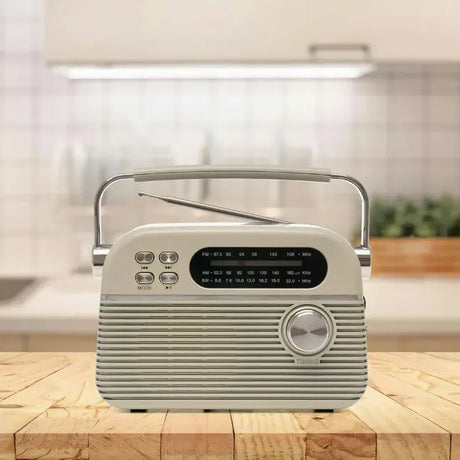 Cream-coloured Lloytron Bolero retro portable radio with ribbed plastic casing, digital display, tuning dial, and carrying handle, positioned on wooden surface in modern kitchen setting