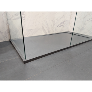 Modern rectangular shower tray in slate grey with 25mm height, installed in contemporary bathroom with marble-effect tile walls and black framed glass enclosure