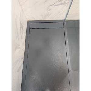 Flair Gemstone Slate rectangular shower tray in dark grey with raised rim and textured surface finish displayed in modern bathroom setting with marble-effect wall tiles
