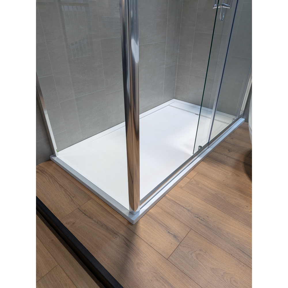 Modern rectangular white shower tray with chrome frame and glass enclosure on wooden floor, Flair Gemstone Slate design with 25mm height