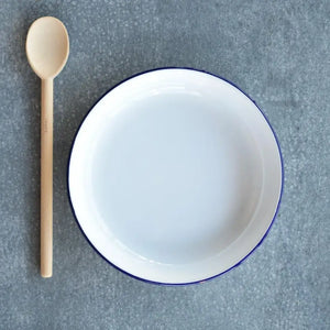 Falcon 24cm enamel rice and pasta dish with navy blue rim and white interior, displayed with wooden spoon on grey textured background