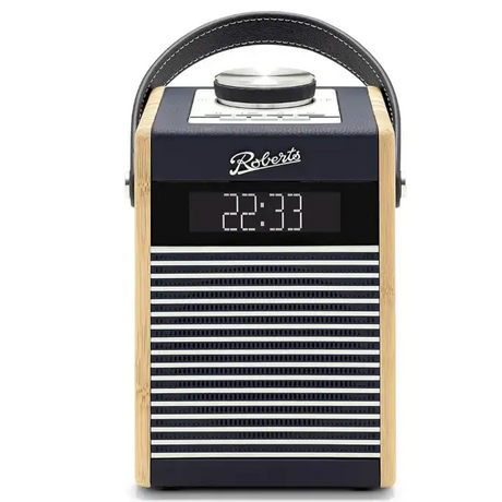 Roberts Rambler Midi DAB+ FM radio with Bluetooth in navy blue and natural wood finish, featuring digital display showing 22:33, horizontal stripe speaker grille, and black leather carrying handle