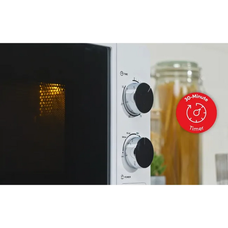 Russell Hobbs white 700W manual microwave with black interior, control dials, and 30-minute timer badge, displayed with pasta jar in background