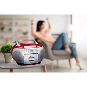 Lenco SCD-420RD red and white portable boombox with cassette and CD player on white table next to potted plant, woman dancing in blurred background
