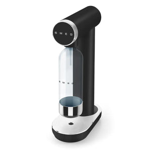 Smeg SKC01BLM matte black sparkling water soda maker with white base, featuring a black control head, clear carbonation bottle with SMEG branding, and stainless steel drip tray in modern retro design