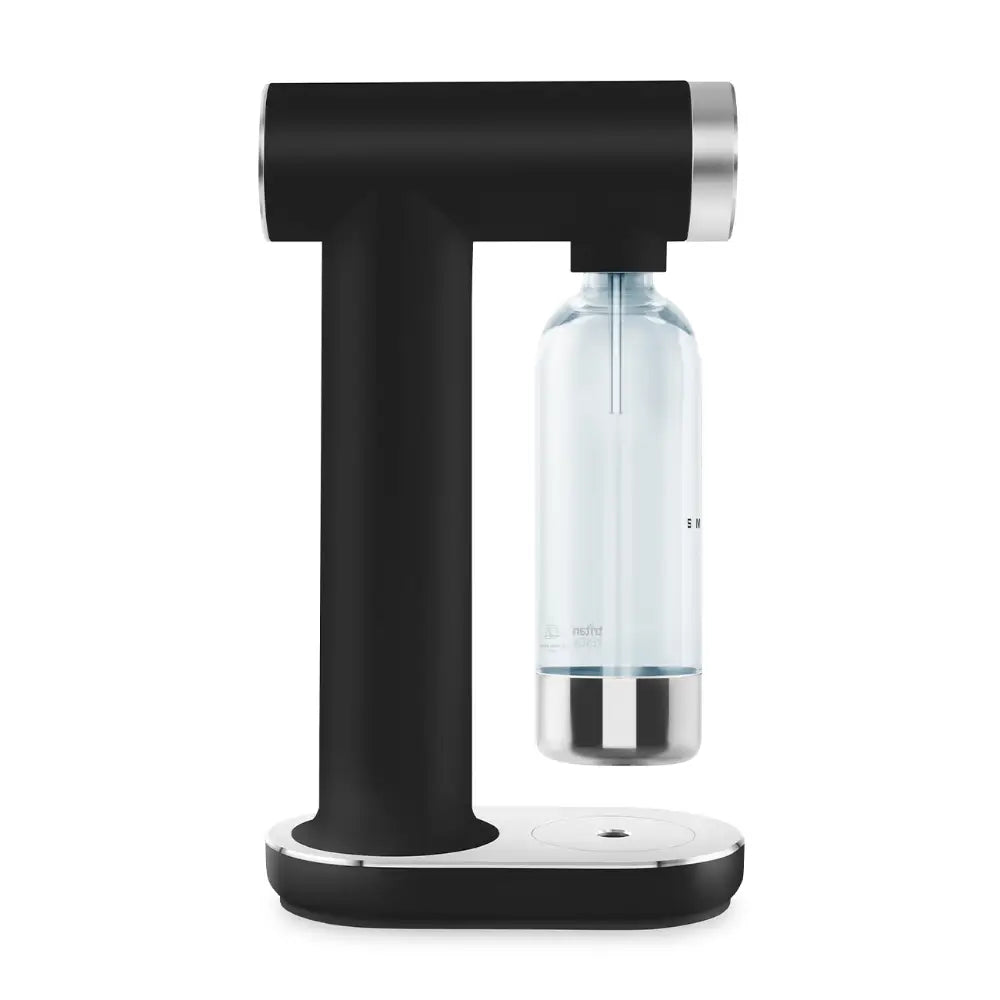 Smeg SKC01BLM matte black sparkling water maker with chrome accents, featuring a T-shaped design with carbonation canister attachment point and clear glass bottle with metal base mounted on white oval base