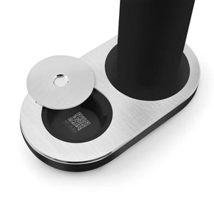 Matte black Smeg sparkling water soda marker with brushed stainless steel top plate and circular opening, shown with black cylindrical insert displaying QR code