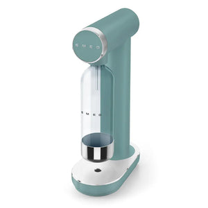 Smeg Sparkling Water Soda Maker in emerald green and white with chrome accents, featuring a cylindrical CO2 cartridge holder, circular control dial, and stainless steel drip tray, displayed against a white background