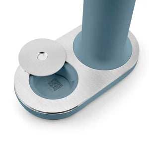 Smeg Sparkling Water Soda Maker in Storm Blue with white metal base and dispensing nozzles, showing QR code detail on underside