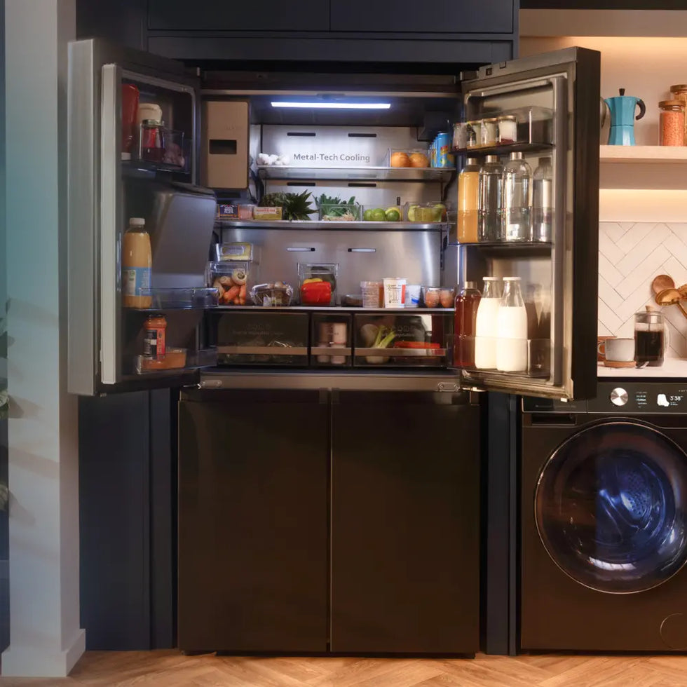 Open Hisense refrigerator with food items inside, next to a washing machine in a kitchen.