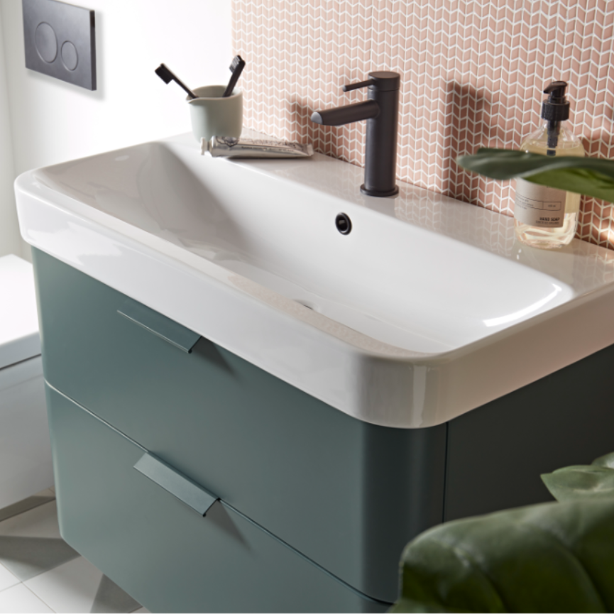 Roper Rhodes System vanity unit with Derwent Blue base cabinet, white ceramic basin, black mono tap, and peach geometric patterned wall tiles in modern bathroom setting