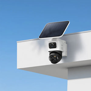 Security camera with solar panel on a metal surface against a blue sky